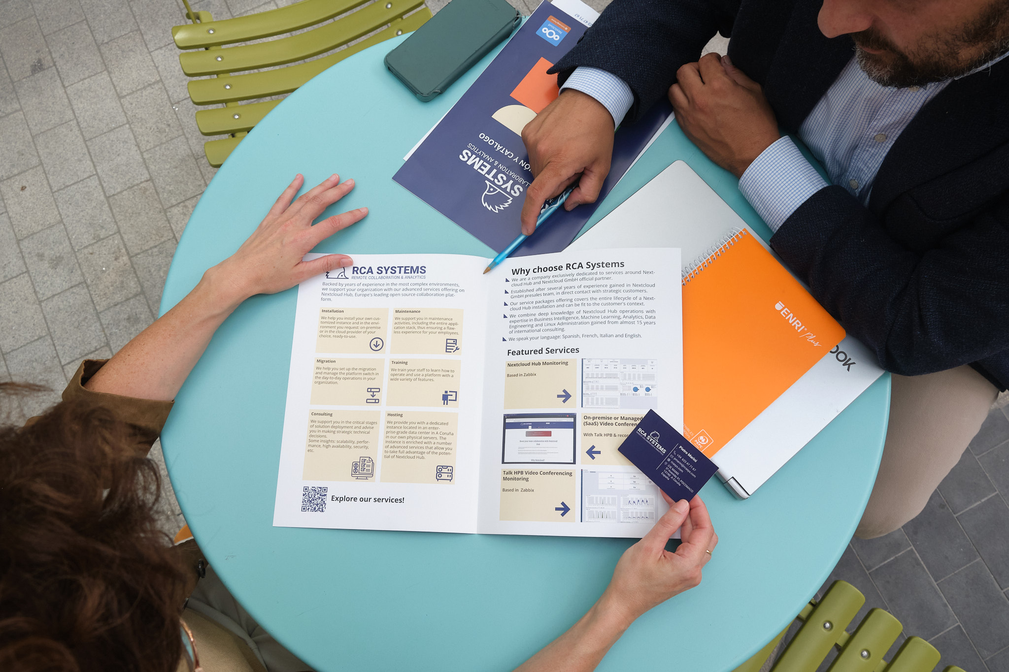 A man and a woman reading RCA Systems-branded promotional material 